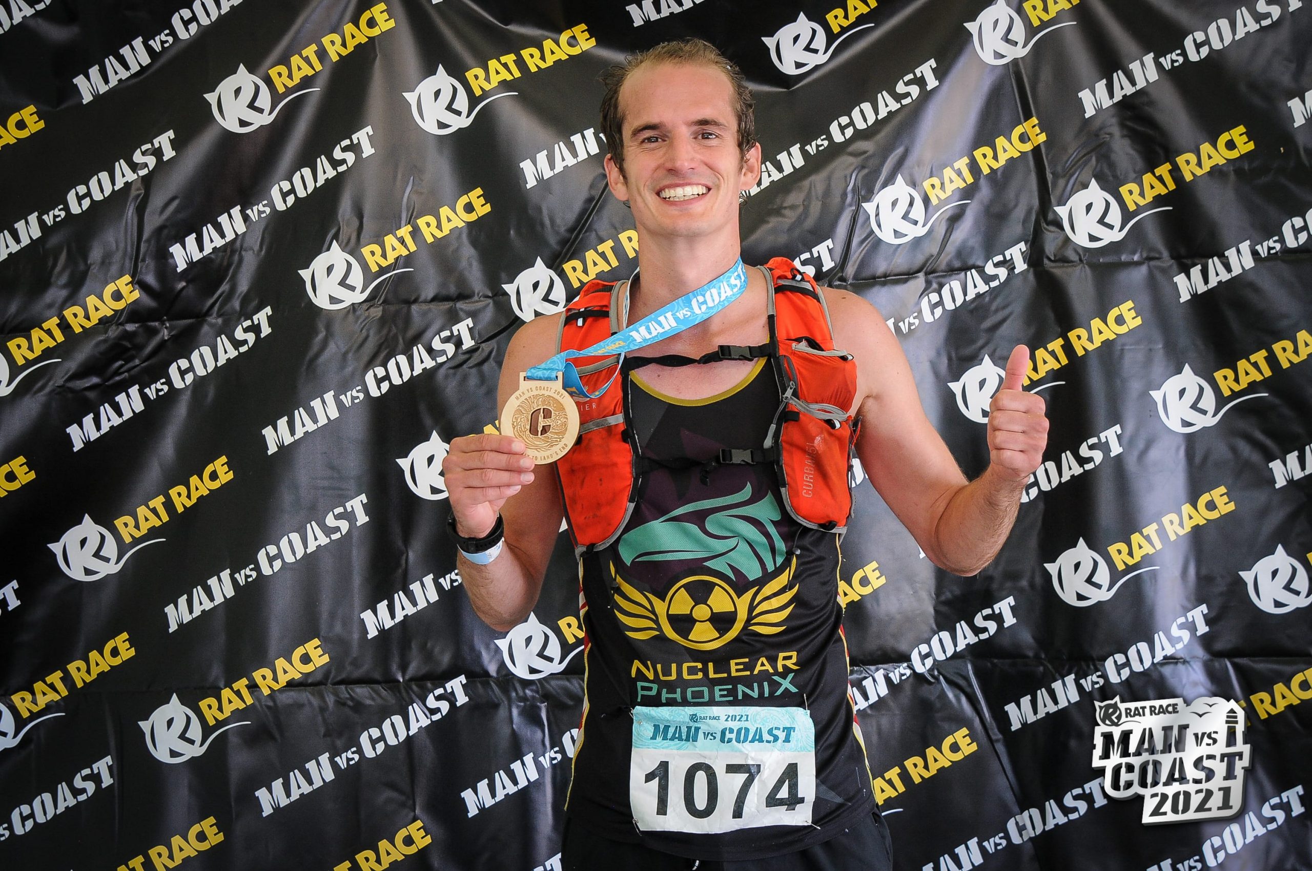 The Man vs. Coast finisher photo with medal in hand.